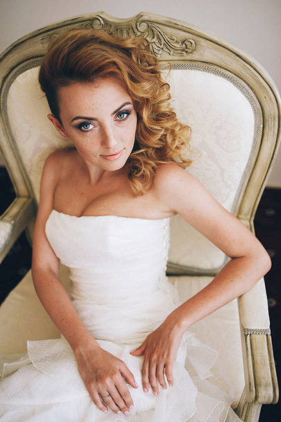 Bride in wedding dress sitting in chair - Photo, image