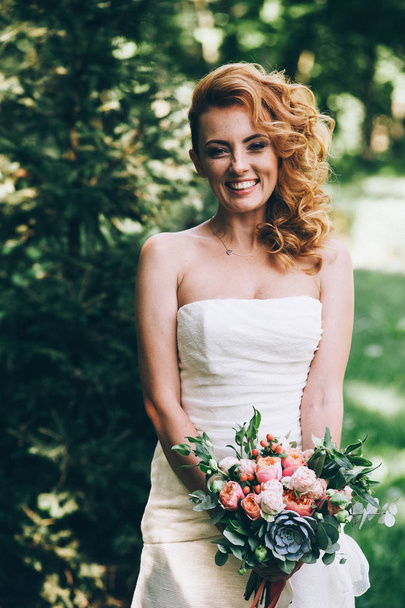 Bride posing with bouquet of flowers - Фото, зображення