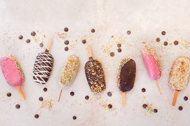 Ice cream sticks with chocolate, fruit, roasted almonds and colourful sugar sprinkles - Foto, immagini