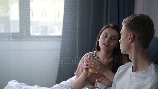 Loving couple having breakfast lying in bed - Πλάνα, βίντεο