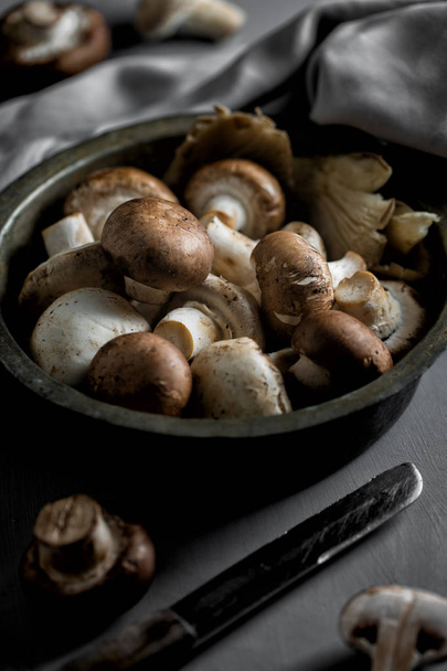 Mushrooms in vintage pan on gray wooden background - Foto, afbeelding