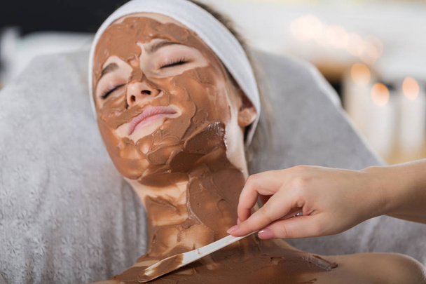 Woman getting chocolate mask treatment in spa - Photo, Image
