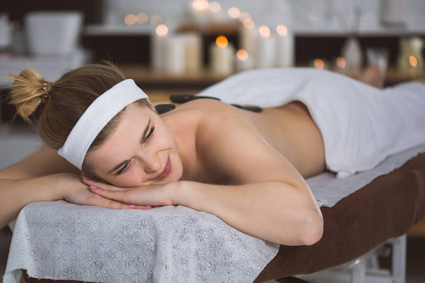 Young woman getting lastone therapy in spa - Photo, image