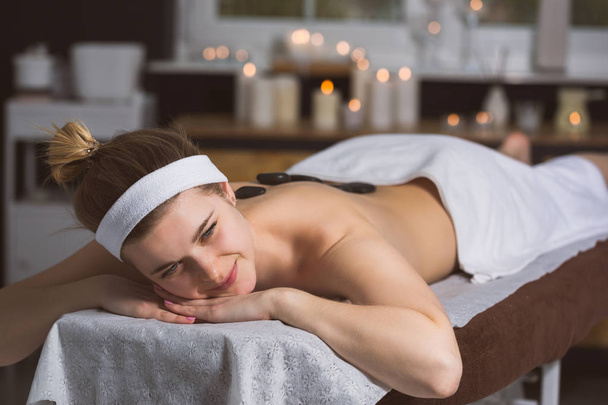 Young woman getting lastone therapy in spa - Photo, image