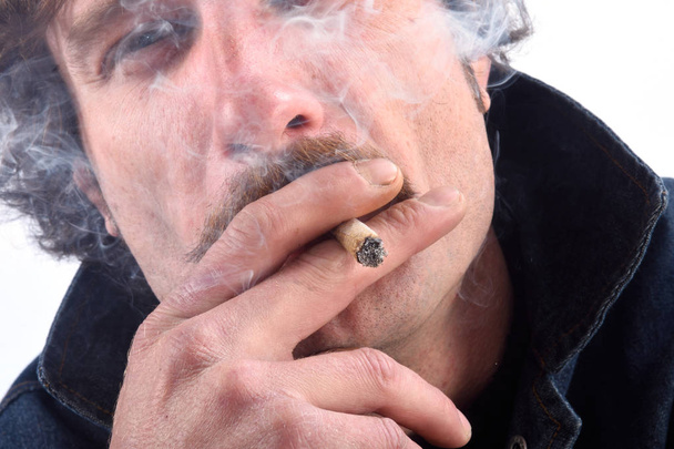 Retrato de un hombre fumando tabaco mentiroso sobre fondo blanco
 - Foto, Imagen