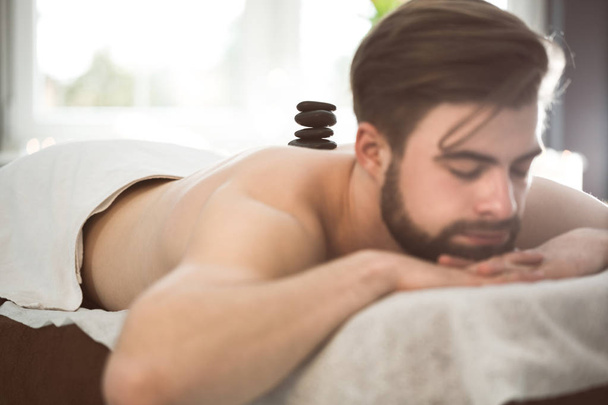 Man relaxing during lastone therapy - Valokuva, kuva