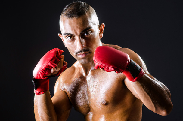 Boxeador con guantes rojos en habitación oscura
 - Foto, Imagen