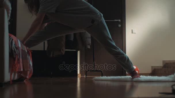 Jeune femme flexible dans le salon glisse sur le tapis et fait accidentellement des fentes
 - Séquence, vidéo