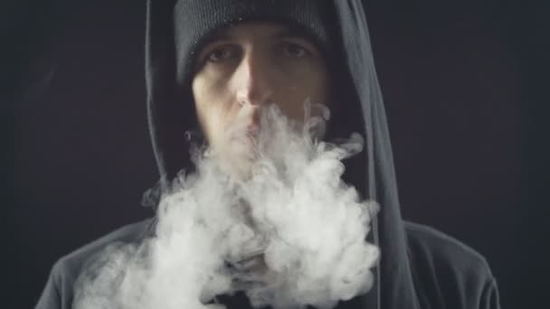 joven vaper hombre exhalando grandes nubes de humo con vapor de cigarrillo electrónico en cámara lenta
 - Imágenes, Vídeo