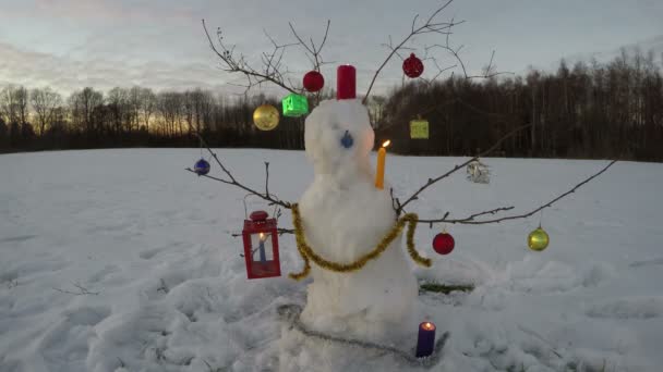 Διακόσμηση χιονάνθρωπος χρόνο Χριστουγέννων Πρωτοχρονιάς στο πεδίο με τα κεριά, ώρα λήξη 4k - Πλάνα, βίντεο