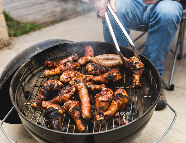 Uomo grigliate di carne sulla griglia barbecue
 - Foto, immagini