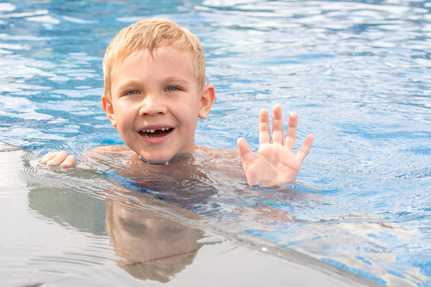 Αγόρι κολυμπώντας και παίζοντας σε μια πισίνα - Φωτογραφία, εικόνα