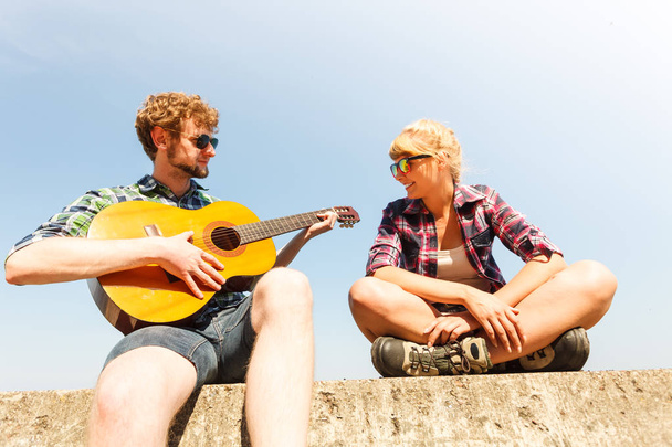 Young man hipster playing guitar for woman. - Foto, immagini