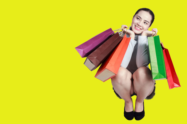 Vrouw op zoek naar de kant op g boodschappentassen met winkelen - Foto, afbeelding