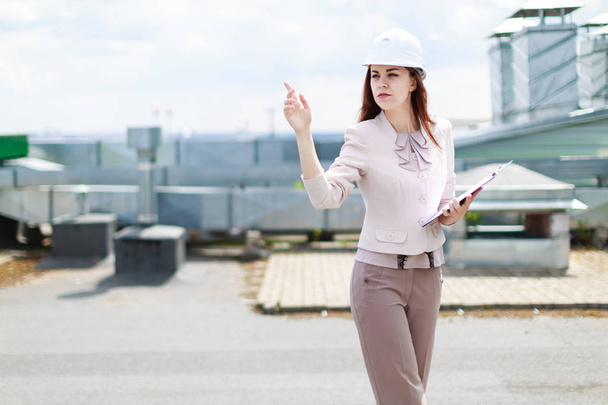 Attractive business lady in hardhat on the roof - 写真・画像