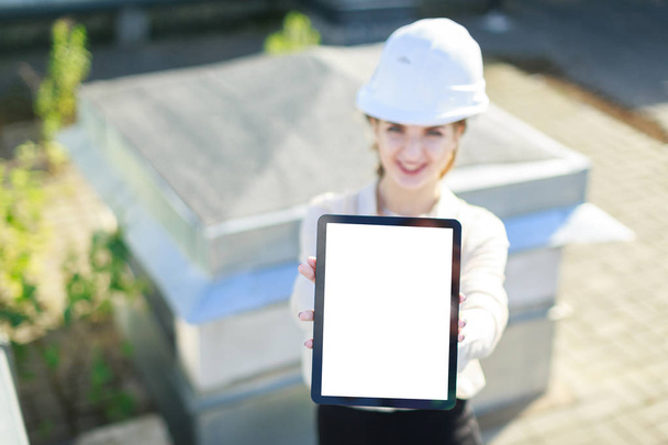 Empresária no capacete no telhado com tablet
 - Foto, Imagem