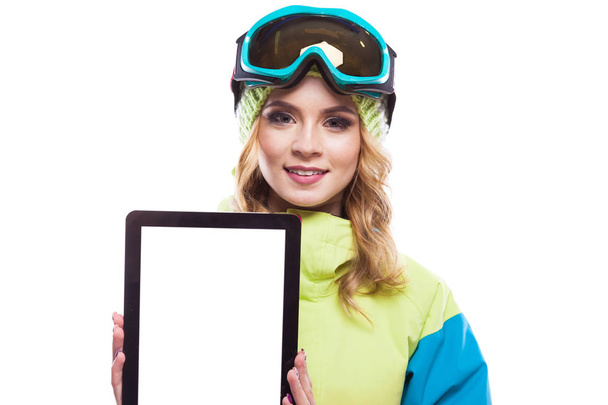 vrouw in ski pak met lege tablet - Foto, afbeelding