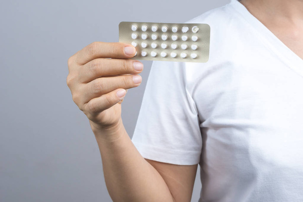 Nainen käsi kädessä pakkaus ehkäisypillereitä, syntyvyyden säännöstely minua
 - Valokuva, kuva