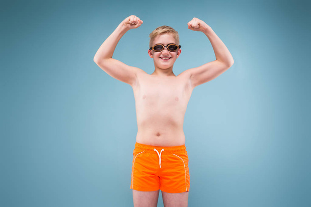 jongen in oranje pak en bril zwemmen - Foto, afbeelding