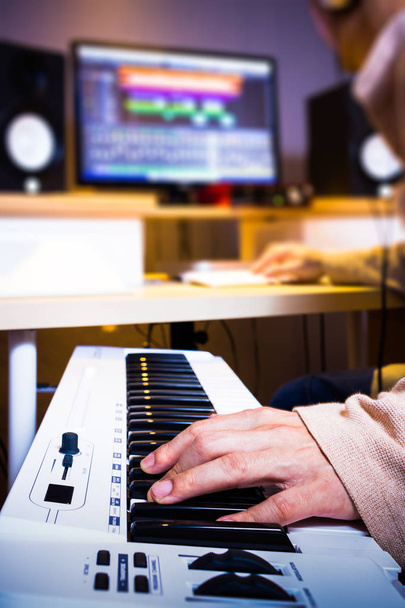 asian arranger hands working on keyboards in recording studio for music production concept - Foto, afbeelding