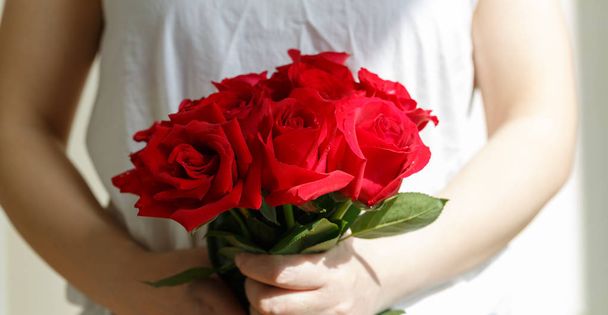 Una mujer de blanco con una rosa en la mano
 - Foto, imagen