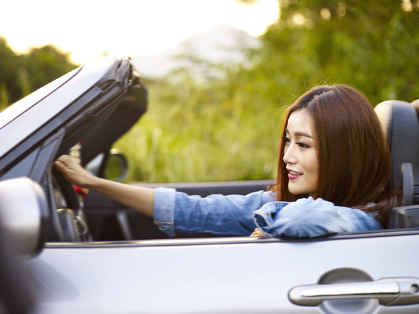 junge asiatische Frau fährt in einem Cabrio Auto - Foto, Bild