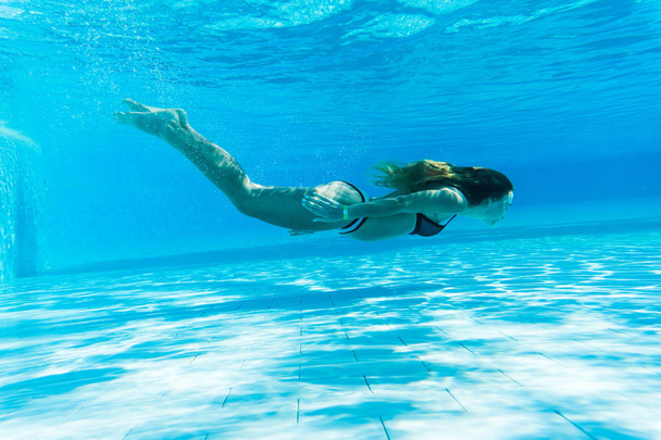 girl snorkel under blue water in swimming pool - Фото, зображення