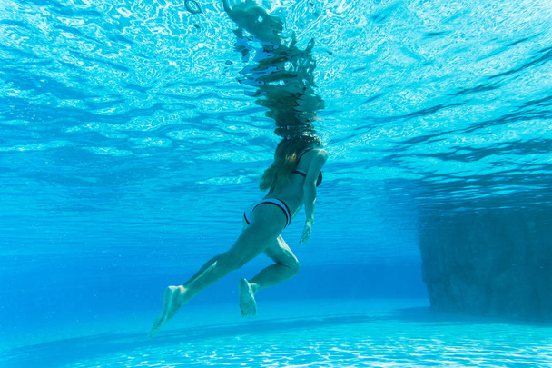girl dive under blue water snorkeling in pool. Summer vocation - Фото, зображення