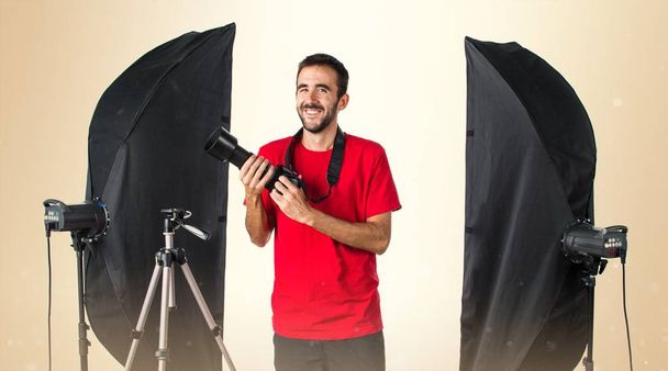 Photographer in his studio on ocher background - Photo, Image