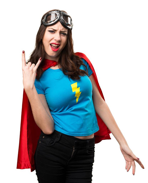 Досить супергеройська дівчина робить жест рога
 - Фото, зображення