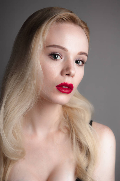 Beauty model girl with perfect make-up red lips and blue eyes looking at camera. Portrait of attractive young woman with blond hair. Beautiful female face with clear fresh skin. Fashion close up shot. - Φωτογραφία, εικόνα