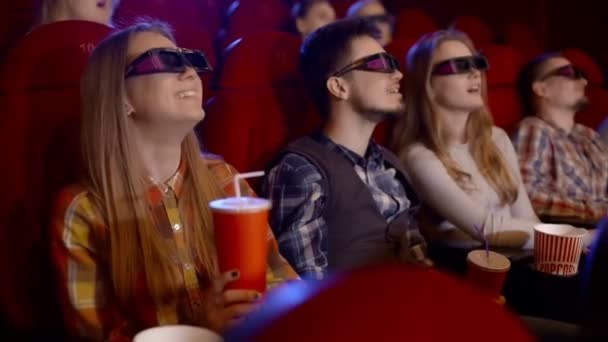 Los jóvenes ven películas en el cine, ven una comedia en 3D, todos sonriendo y comiendo palomitas de maíz
. - Metraje, vídeo