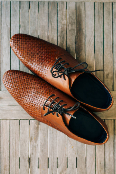 Zapatos hombre marrón con cordones sobre fondo de madera
 - Foto, imagen