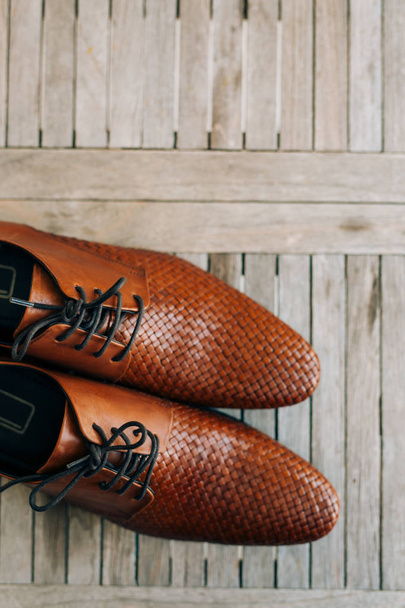 Brown man shoes with laces on wooden background - Foto, Imagem