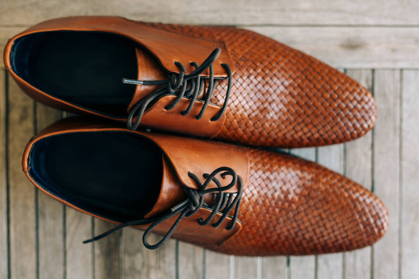 Коричневий людина взуття з шнурками на дерев'яними тлі - Фото, зображення