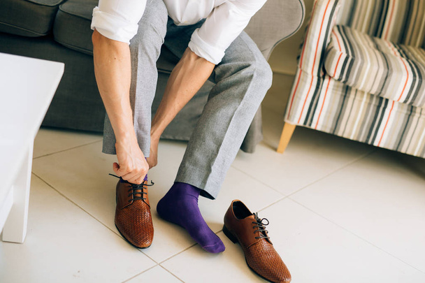 De man in de grijze broek en een paarse jurk sokken bruine schoenen met - Foto, afbeelding