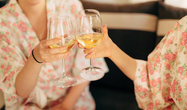 De meisjes clink glazen champagne in gewaden - Foto, afbeelding