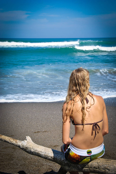 nuori vaalea nainen istuu rannalla
 - Valokuva, kuva
