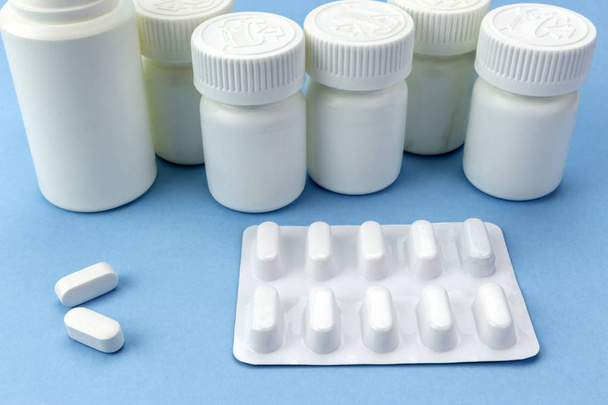 Kék háttér fehér, fehér tabletta különböző típusú tabletták csónakok - Fotó, kép