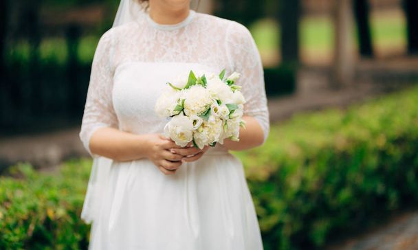 Rose nuziali e peonie nelle mani della sposa. Matrimonio in
 - Foto, immagini