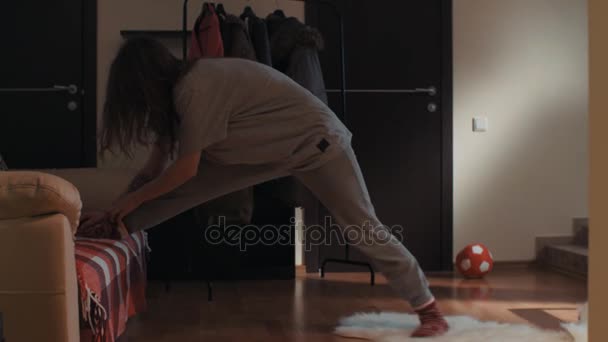 Młoda Dziewczyna Brunetka w pokój dzienny ślizga się na dywan i przypadkowo sprawia, że podziały - Materiał filmowy, wideo