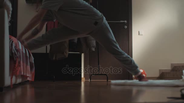 Młoda Dziewczyna Brunetka w pokój dzienny ślizga się na dywan i ciągnie się po podłodze - Materiał filmowy, wideo