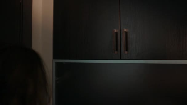 Onherkenbaar jonge vrouw opent muur kast, heleboel vakken valt uit - Video