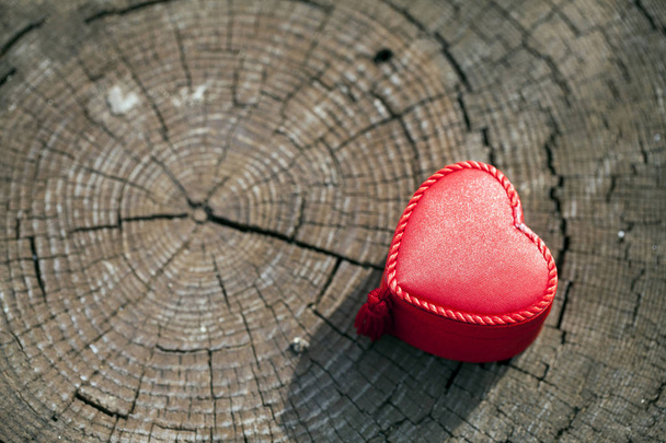 Forme de coeur de la boîte cadeau sur le tronc en bois
 - Photo, image