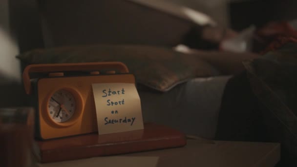 Κίτρινο ραδιόφωνο ξυπνητήρι σε κρεβάτι τραπέζι με κίνητρο αυτοκόλλητο πάνω - Πλάνα, βίντεο