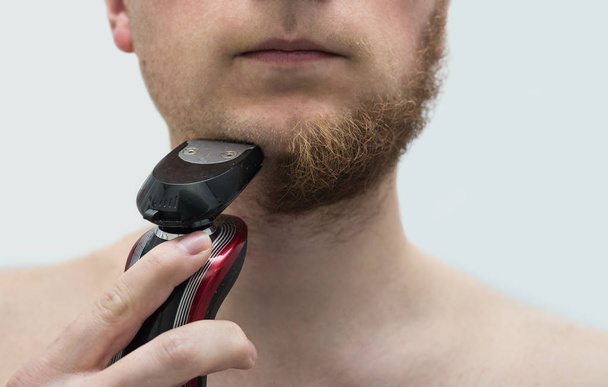 young man shaving his beard off - Foto, imagen