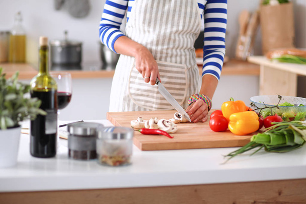 Giovane donna che taglia verdure in cucina a casa - Foto, immagini