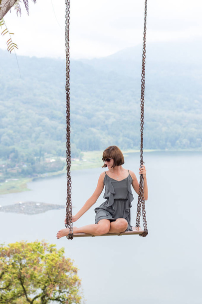 Σέξι νεαρή aldy αιωρούνται πάνω από τον γκρεμό στο μαγικό τροπικό νησί Μπαλί, Ινδονησία. - Φωτογραφία, εικόνα