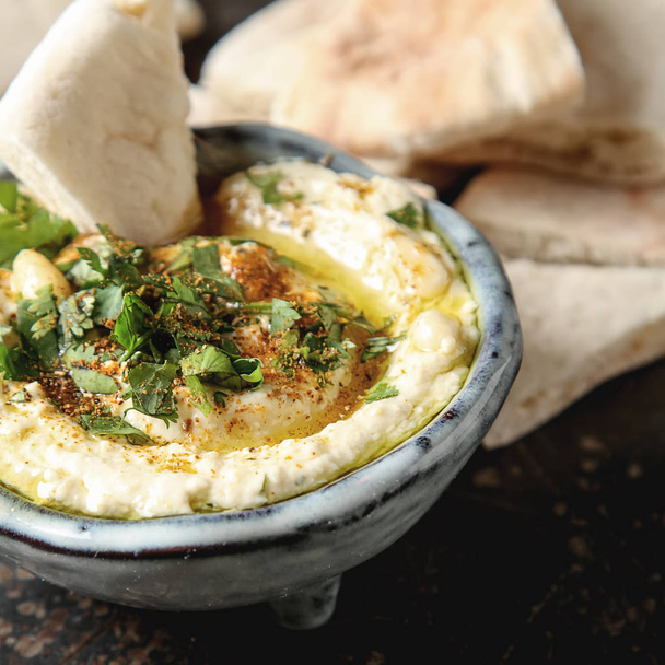 Classic hummus with herbs, olive oil in a vintage ceramic bowl a - 写真・画像