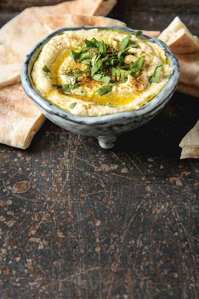 Classic hummus with herbs, olive oil in a vintage ceramic bowl a - Valokuva, kuva